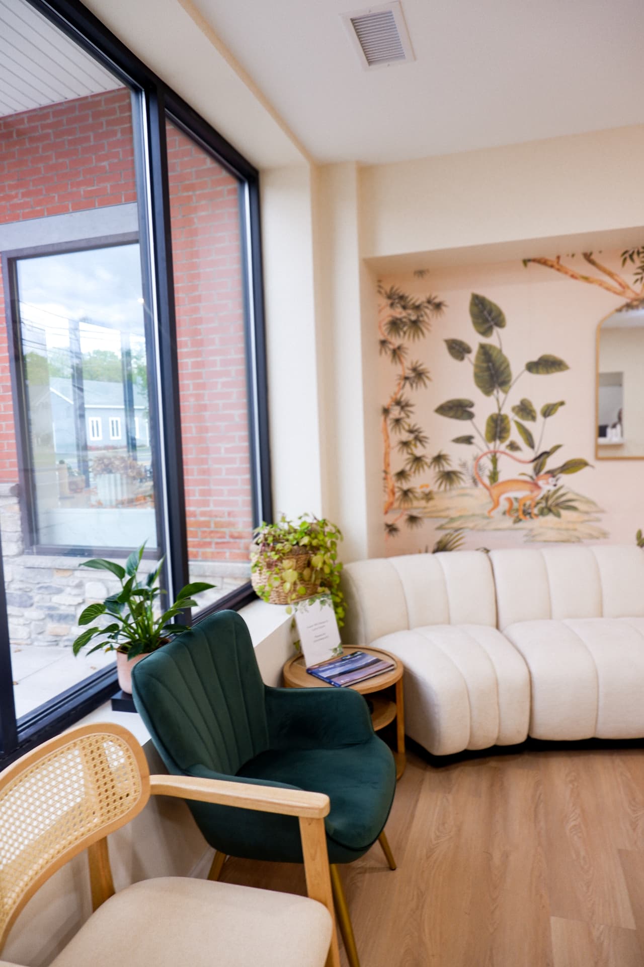 Sunlit lounge with curved sofa and botanical mural